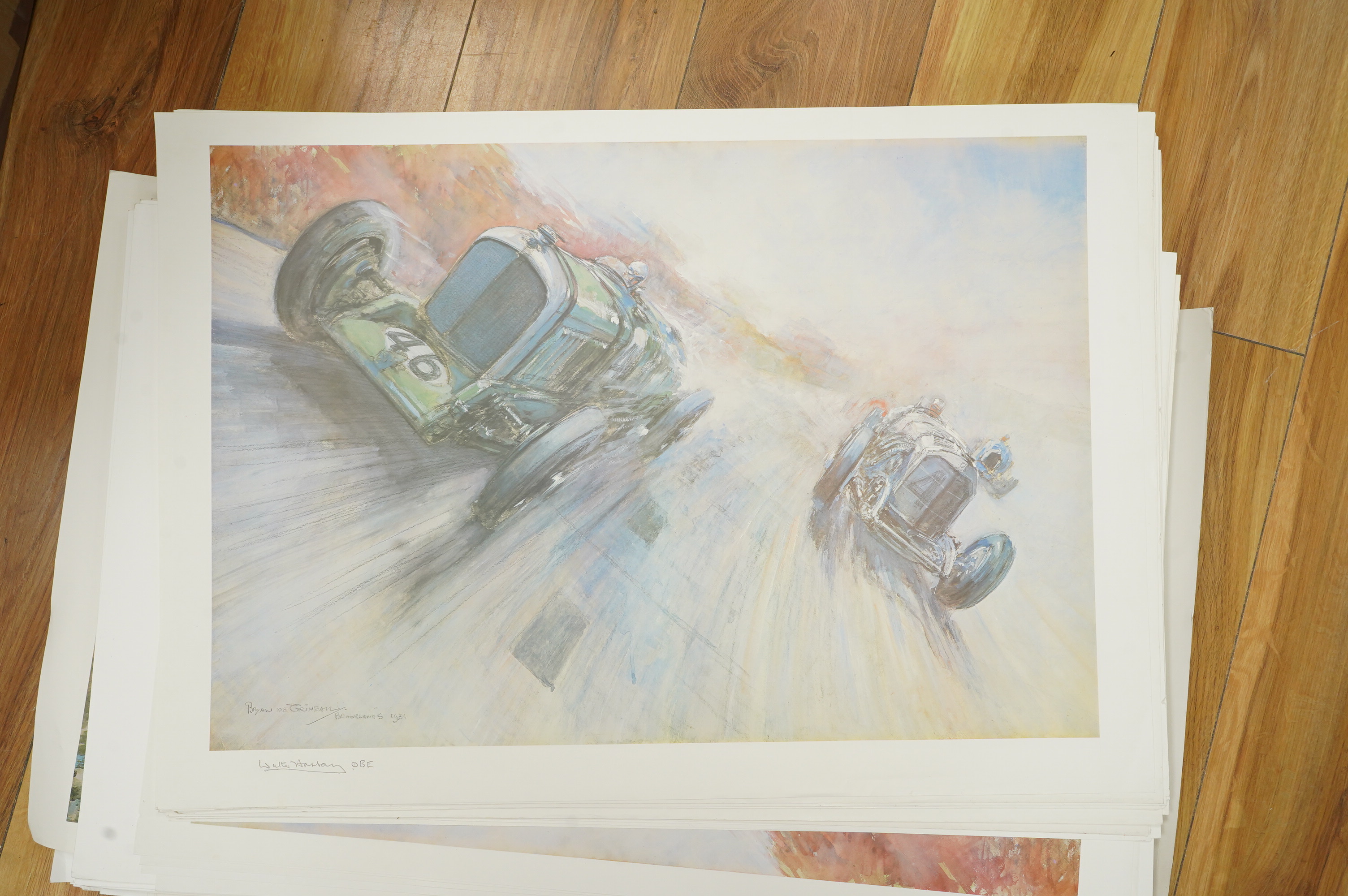 Two framed and signed motor racing lithographs by Anthony Heal and Walter Hassan of Le Mans and Brookslands racing scenes, the largest frame 61.5 x 76cm, together with a folio containing a large number of unframed simila